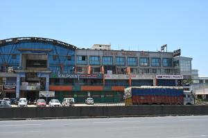 un grande edificio con macchine parcheggiate di fronte di Hotel Anand Inn a Vapi