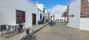 a patio with tables and chairs in a building at Sabbia Suites Casa San Miguel in Teguise