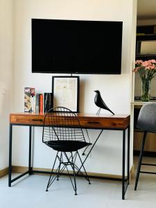 a desk with a television and a black bird on it at Loft luminoso y moderno con excelentes vistas in Medellín