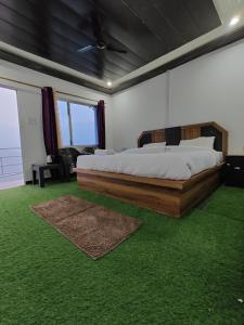 a bedroom with a large bed and green carpet at Belle Vue Chopta in Barmoāri