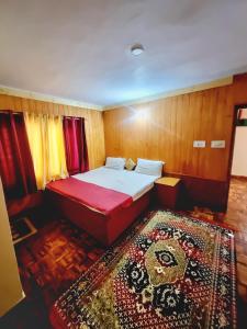 Dormitorio pequeño con cama y alfombra en Snow land cottage, en Manali