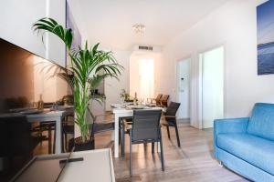 un soggiorno con tavolo e divano blu di Elegance Suite Apartments a Cervia
