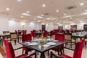 un salón de banquetes con mesas y sillas rojas en Shree Vallabh Vilas Lords Plaza, en Eklingji