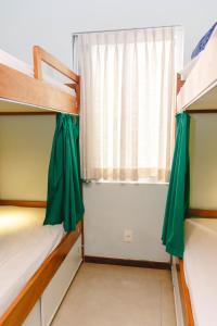 1 dormitorio con 2 literas y ventana en Palace Beach Hostel en Río de Janeiro