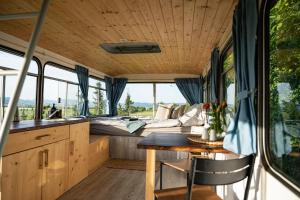 eine Küche und ein Essbereich eines Wohngebäudes mit einem Bett in der Unterkunft Bus Ikarus in Prievidza