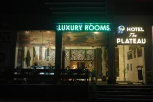 un hotel con un letrero de neón en la oscuridad en Hotel The Plateau, en Ranchi
