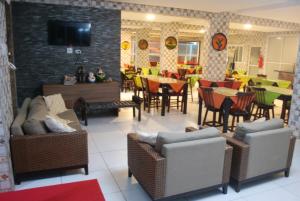 una sala de estar con sillas y mesas y un restaurante en Pousada Brasileira, en Porto de Galinhas