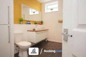 y baño con aseo blanco y lavamanos. en Modern 3 bed Terraced House By NYOS PROPERTIES Short Lets & Serviced Accommodation Manchester With Free WiFi, en Mánchester