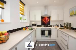 una cocina blanca con un corazón en la estufa en Modern 3 bed Terraced House By NYOS PROPERTIES Short Lets & Serviced Accommodation Manchester With Free WiFi, en Mánchester