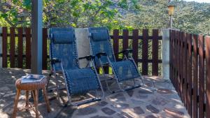 une paire de chaises bleues assises à côté d'une clôture dans l'établissement Casa Cedro, à Porto Ottiolu