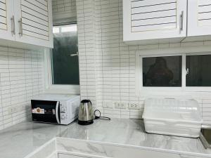 a kitchen with a counter top with a microwave at 93 House in Ban Bang Toei (1)