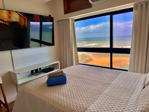 um quarto com uma cama e vista para o oceano em Ondina Apart Hotel Residences em Salvador