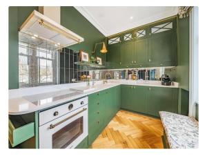 a kitchen with green cabinets and a white sink at Boutique Studio in Putney,Wimbledon in London