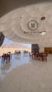 a dining area with tables and chairs in a room at Moon Island Camp in Wadi Rum