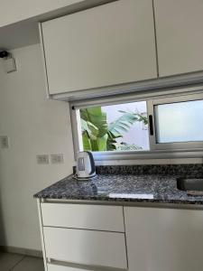 uma cozinha com uma janela e uma bancada em Dos ambientes San Justo em San Justo
