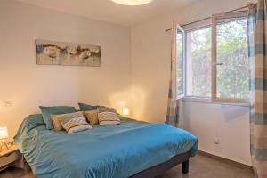 um quarto com uma cama com lençóis azuis e uma janela em Casa U Castagnettu em Patrimonio