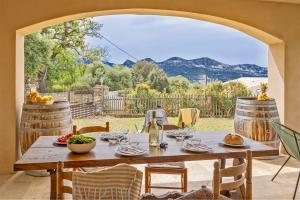een houten tafel met wijnglazen op een patio bij Casa U Castagnettu in Patrimonio