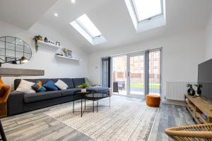 a living room with a couch and a table at Spacious & Modern 4-Bedroom Townhouse in Manchester