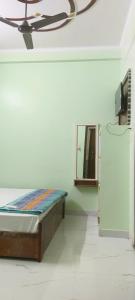 1 dormitorio con cama y espejo en la pared en Ram Bila paying guest house en Ayodhya