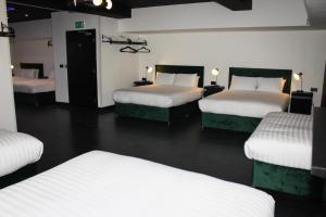 una habitación con cuatro camas en una habitación en The Hideaway by Boutique 56, en Liverpool 12 fotos más