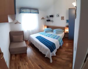 een slaapkamer met een bed, een stoel en een raam bij Apartments Demori in Galižana