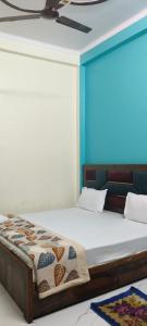 Cama en habitación con pared azul en Ram Bila paying guest house en Ayodhya