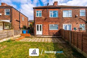 a brick house with a fence in front of it at 3 Bed House With Parking By NYOS PROPERTIES Short Lets & Serviced Accommodation Manchester in Manchester