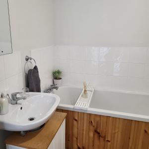 a bathroom with a sink and a bath tub at Woodside guest house in Castlerock