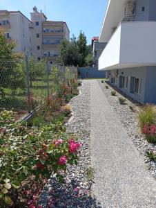 een tuin met roze bloemen en een hek bij Z BOUTIQUE STUDIOS in Perea