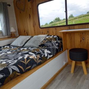 a bed in the back of a boat with a window at Camping car vintage in Saint-Barthélemy-le-Plain +22 photos
