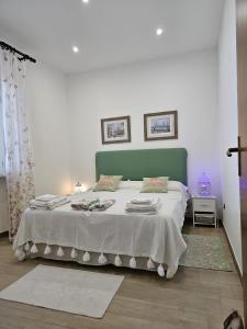 a bedroom with a large bed with a green headboard at Naturoasi Resort in Belvedere Marittimo
