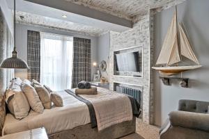 a bedroom with a large bed and a sailboat on the wall at Finest Retreats - The Old Library in Dartmouth