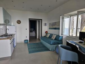 a living room with a blue couch and a kitchen at Naturoasi Resort in Belvedere Marittimo