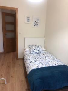 a small bedroom with a bed with a blue blanket at Alojamiento ideal en Santiago in Santiago de Compostela