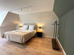 ein Schlafzimmer mit einem Bett und zwei Lampen auf einem Holzboden in der Unterkunft Haus Kranenborgh im Mühlenspiegel Steinhude am Meer in Steinhude