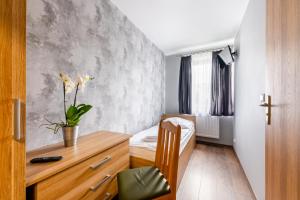 a bedroom with a bed and a desk with a plant at Sleep&Go in Lubliniec