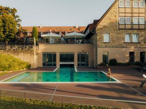 an external view of a house with a swimming pool at Hotel Leinsweiler Hof in Leinsweiler