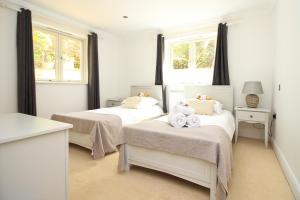 two beds in a white room with two windows at CLOSE TO BEACH, dogs welcome, private garden in St Merryn