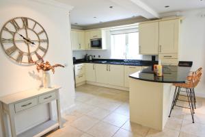 eine Küche mit einer großen Uhr an der Wand in der Unterkunft CLOSE TO BEACH, dogs welcome, private garden in Saint Merryn + 13 Fotos