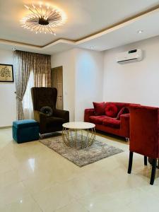 a living room with a red couch and a table at Abefe Realtor in Lekki