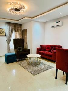 a living room with a red couch and a table at Abefe Realtor in Lekki