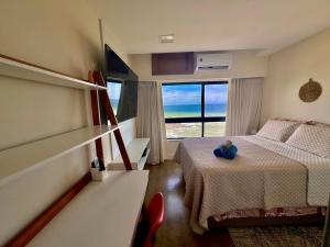 um quarto com uma cama com um urso de peluche sentado sobre ele em Ondina Apart Hotel Residences em Salvador
