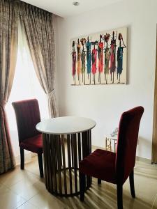 a living room with a table and two chairs and a painting at Abefe Realtor in Lekki