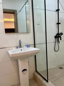 ein Badezimmer mit einem weißen Waschbecken und einer Dusche in der Unterkunft Abefe Realtor in Lekki