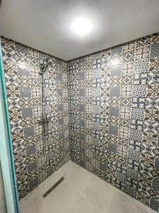 a bathroom with a shower with tiles on the wall at Riad el wazzania in Rabat
