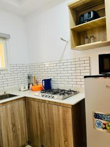 a kitchen with a stove top oven next to a refrigerator at Abefe Realtor in Lekki