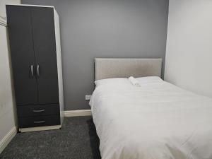 una camera con letto e armadio nero di Hygis Great Home of Relaxations a Stoke on Trent