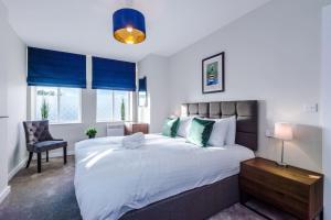a bedroom with a large white bed and a chair at Southport Suites Apartment 4 in Southport