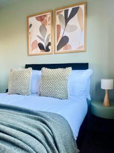 a bedroom with a bed with two pictures on the wall at Castle Gait Apartment in Paisley +11 photos