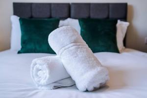 a stack of white towels sitting on a bed at Southport Suites apartment 8 in Southport